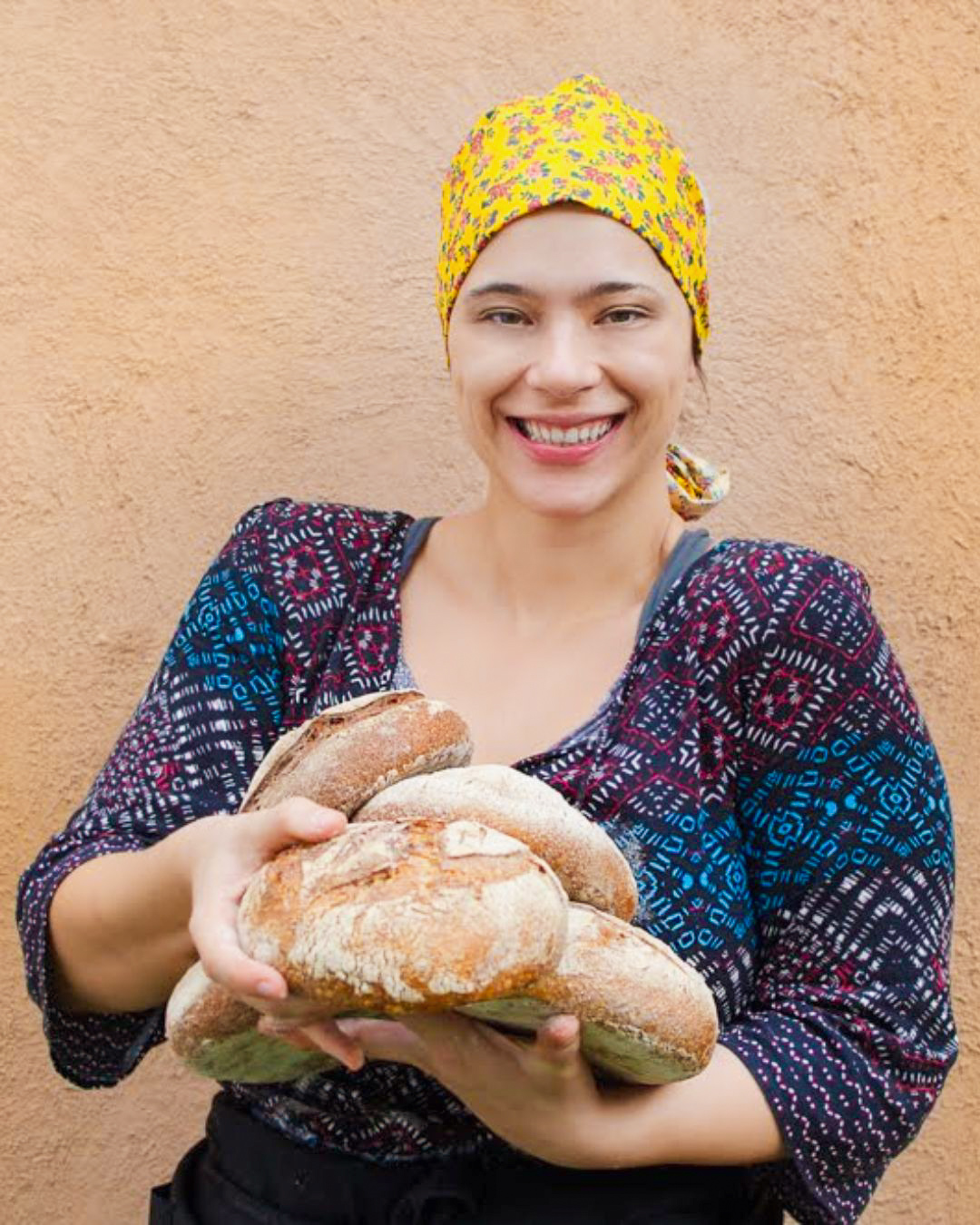 Dani Lisboa sorrindo, segurando paes artesanais recem assados
